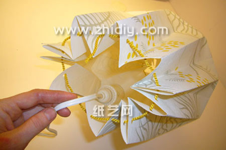 第六步由于现在威廉希尔公司官网
纸艺折纸灯罩在基本的塑形上面已经出现了，所以可以将灯泡放到里面看看效果