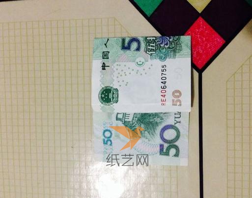 首先用50元人民币先来进行折叠，折叠的时候注意看准威廉希尔中国官网
中折叠的位置